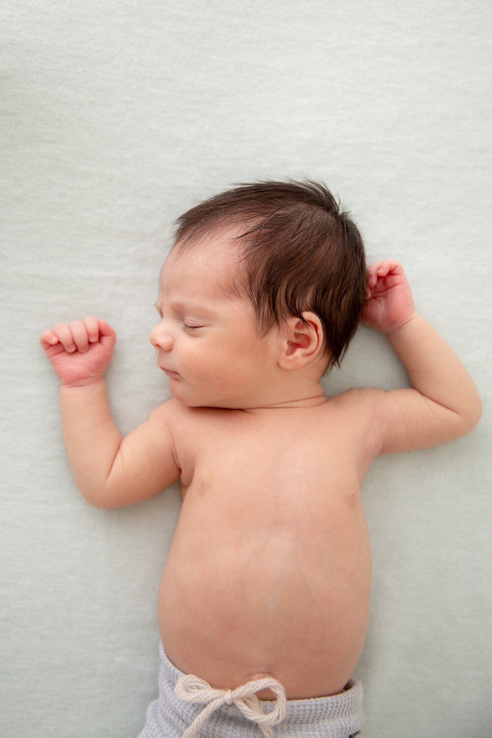 newborn baby on sage backdrop