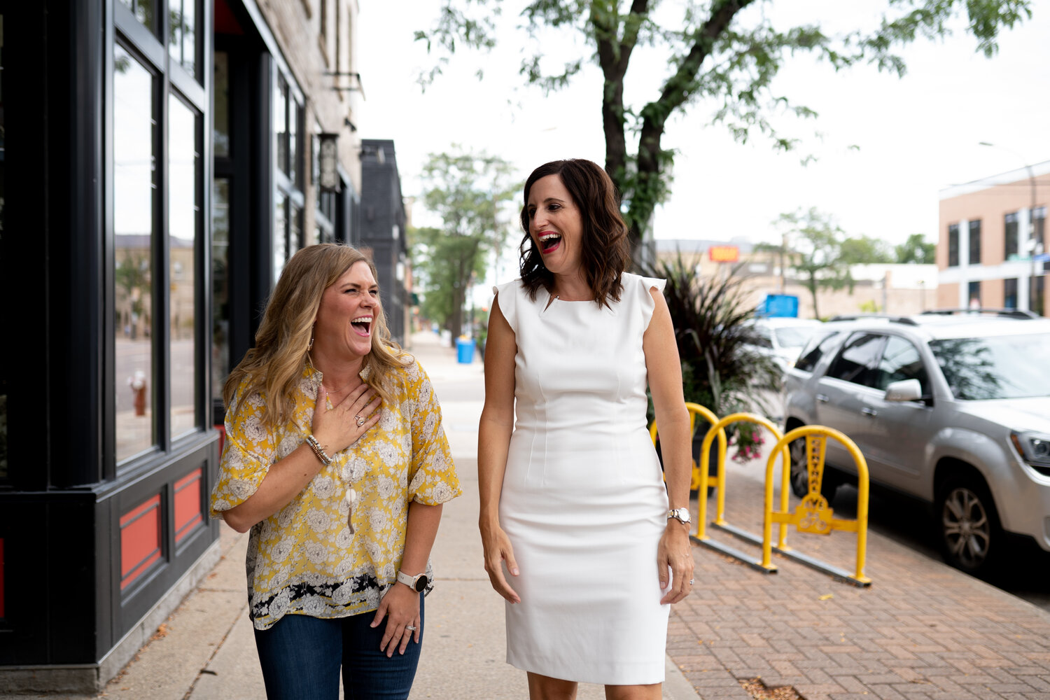 Two women talking and laughing while walking down a Minneapolis street