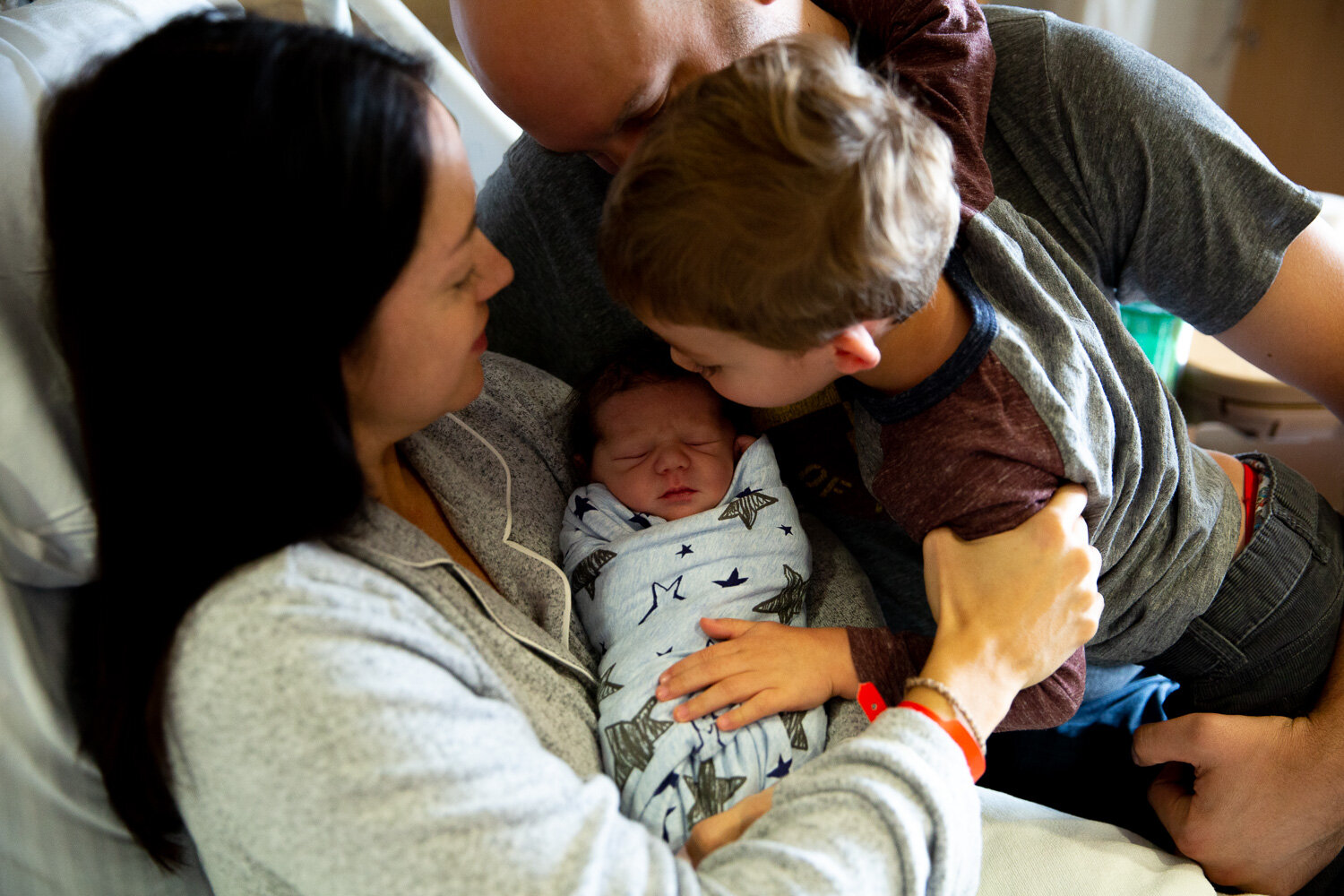 Family gathered around newborn baby in the hospital