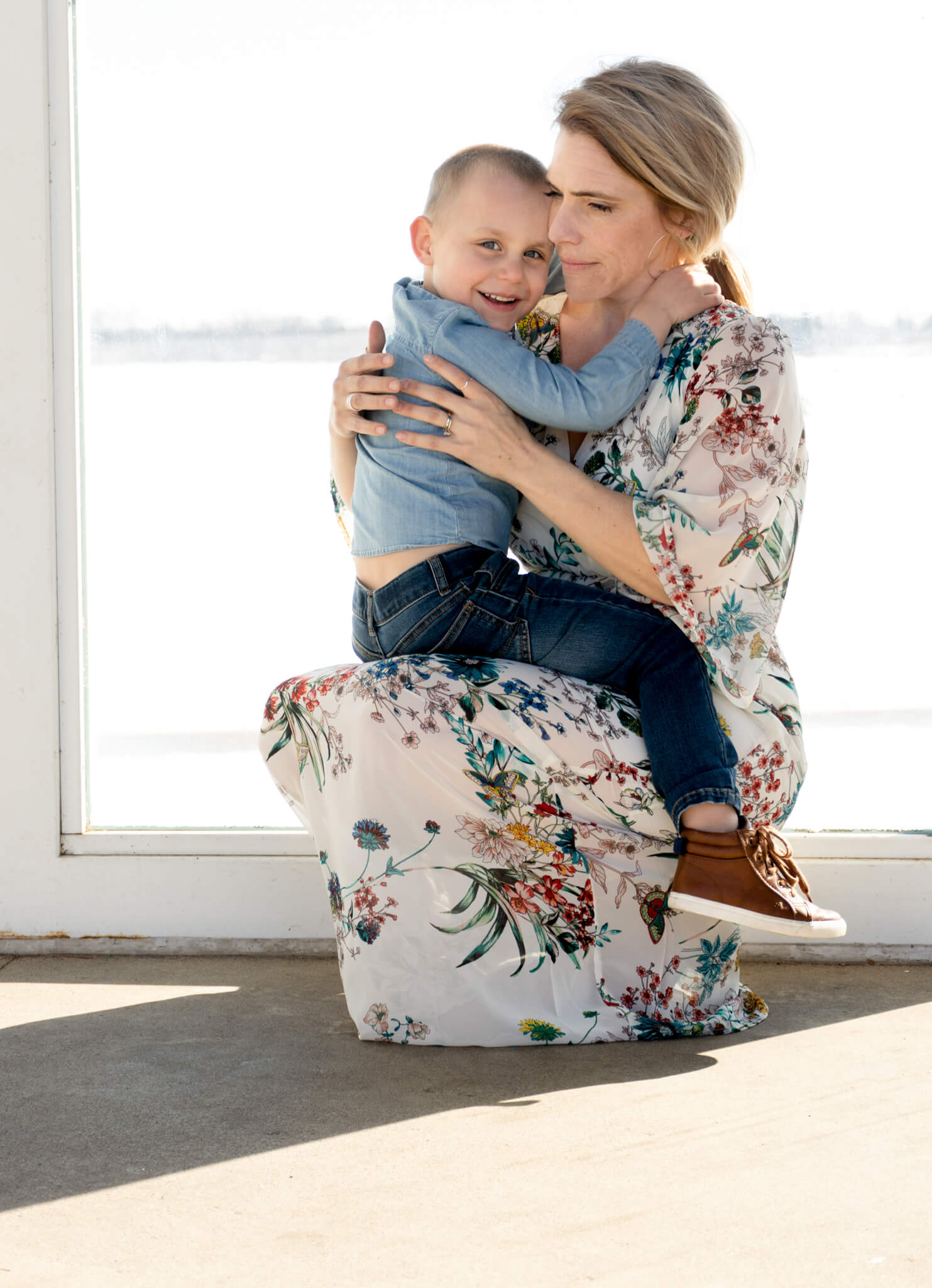 Mom wearing a vintage flower dress holding toddler on her lap at Lake Harriet bandshell