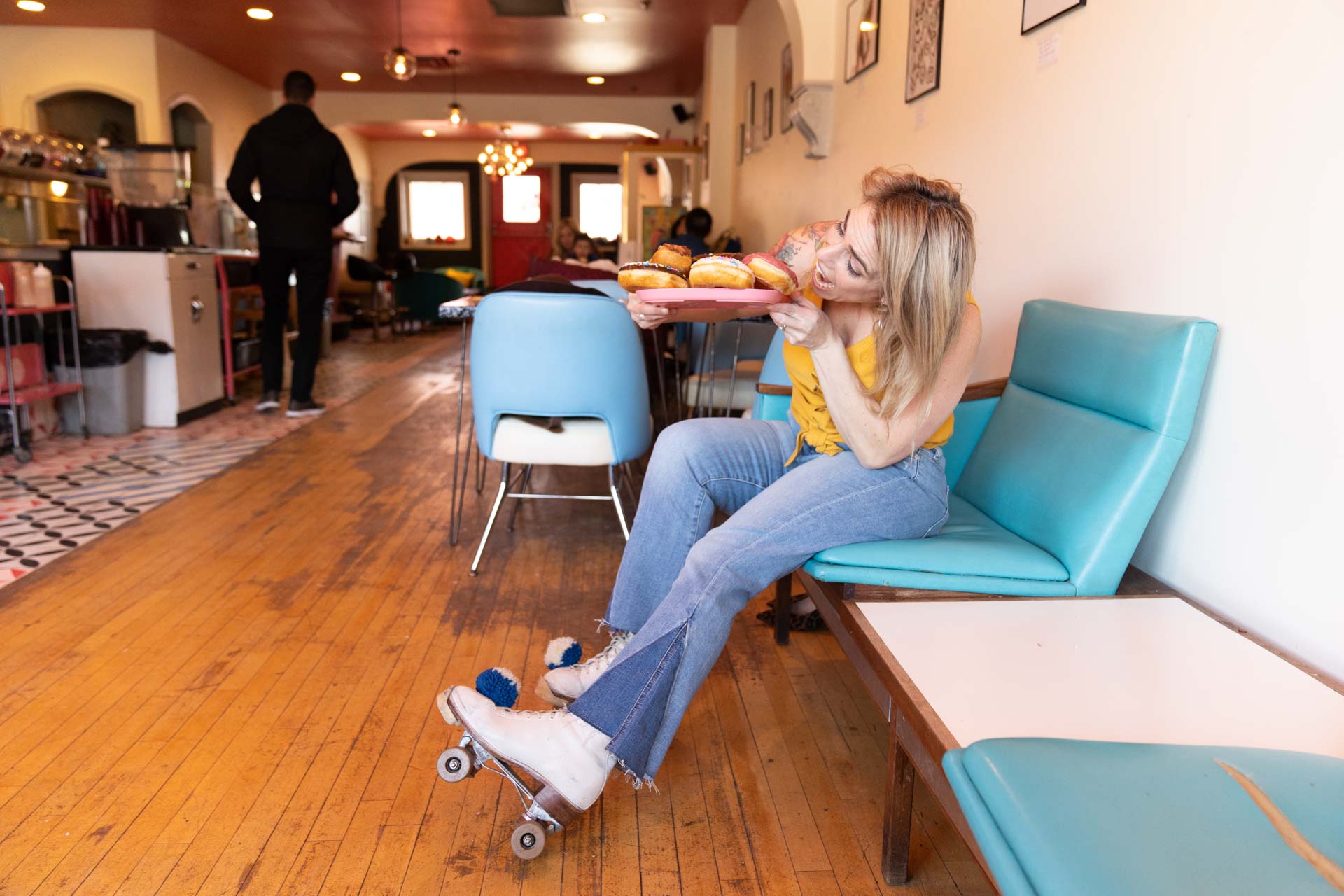 Jessica Strobel about to eat a donut in a retro cafe