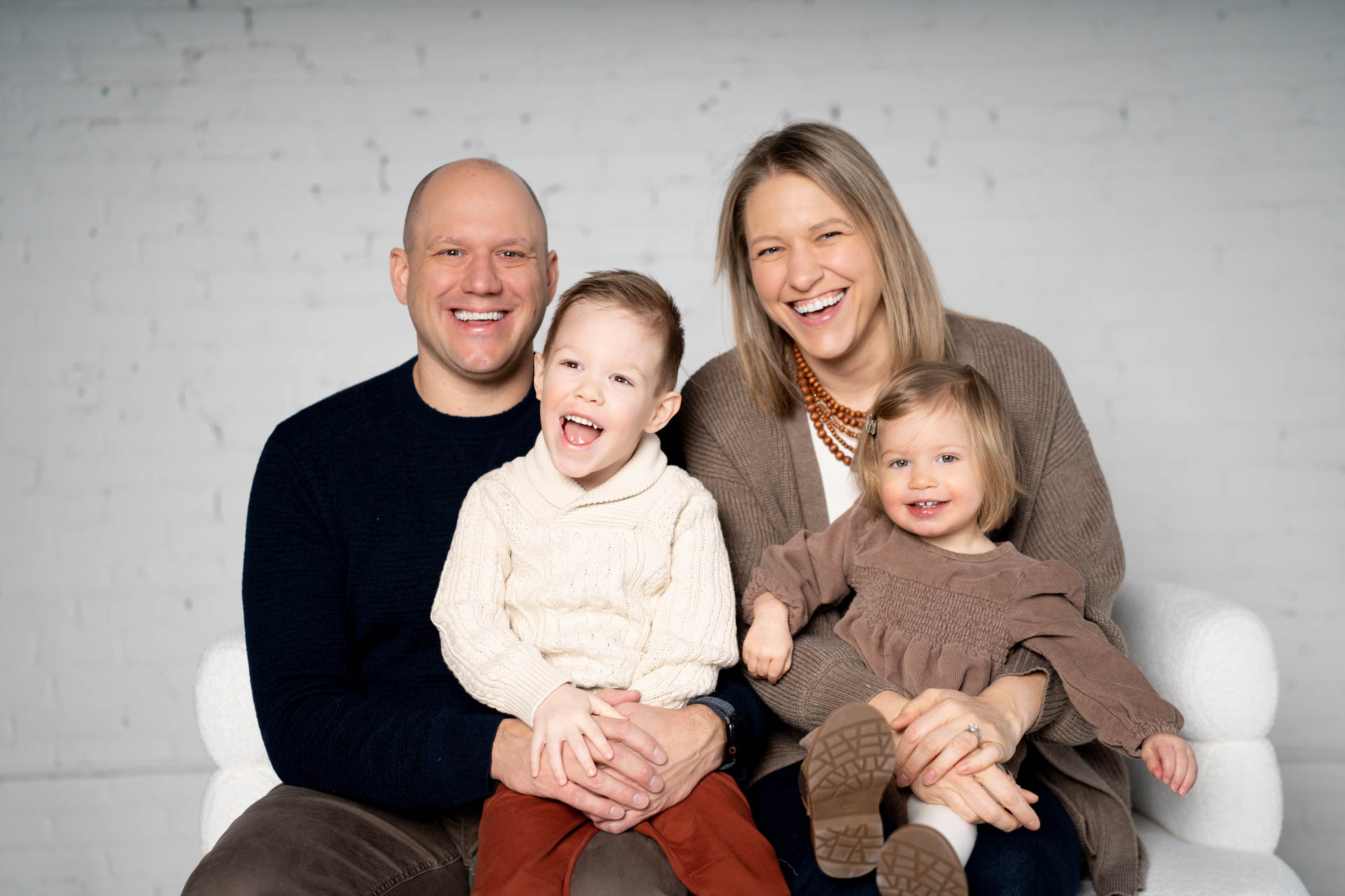 Family of four posed smiling together for Jessica Strobel Photography winter mini sessions