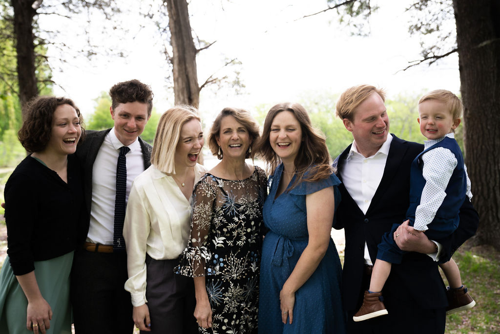 a large family group standing together and laughing candidly while making silly faces at a Minneapolis micro-wedding