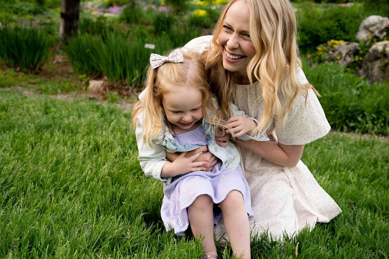 Large family dressed in neutral tones posed in a botanical garden for family photos