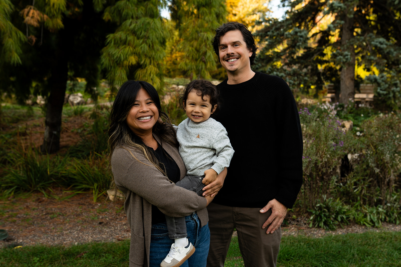 high school senior looking intently into the camera with hazel eyes, in front of a vibrant green and blue mural